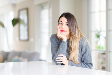 Obraz premium Young beautiful woman wearing winter sweater at home thinking looking tired and bored with depression problems with crossed arms.