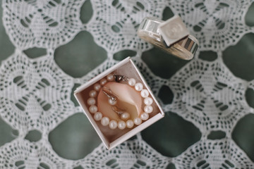 Pearl bracelet, ear rings and perfume. Bridal jewellery. Flat lay. Top view
