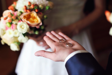 Obraz na płótnie Canvas Hands of groom with rings