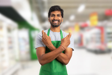 Supermarket worker making good luck gesture.