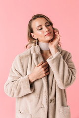 Young pretty woman posing isolated over pink wall background wearing accessories and jewelry.