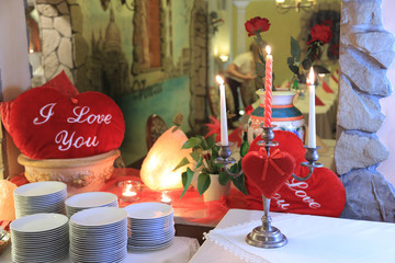 Serca czerwone, świecznik i talerze na stole w restauracji. - obrazy, fototapety, plakaty