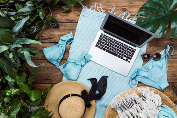 Top view of group of summer objects on wooden background. Swimwear, sunglasses and exotic levies....