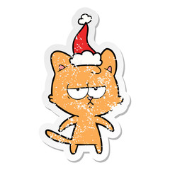 bored distressed sticker cartoon of a cat wearing santa hat