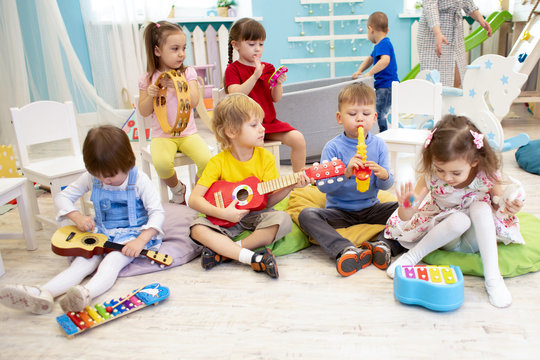Children learning musical instruments on lesson in kindergarten or preschool