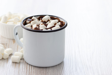 Hot chocolate with marshmallows in a white metal vintage mug