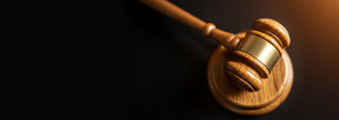 judge or auction Gavel on a wood block in courtroom, dark background