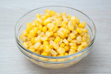 dish of fresh corn grains on a gray table