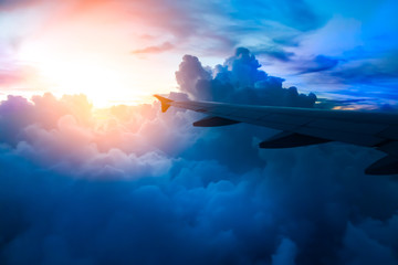 Clouds in the blue sky.View on the sunset and airplane wing from the inside.