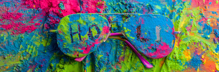 Obraz na płótnie Canvas Holi color powder on sunglasses. Organic Gulal colours on eyeglasses for Holi festival, Hindu tradition festive