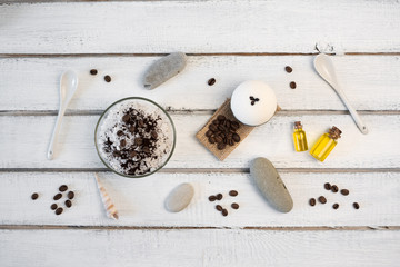 Aromatherapy and spa concept. Spa salt with coffee scent near soap, spa oil and loofah on white background top view