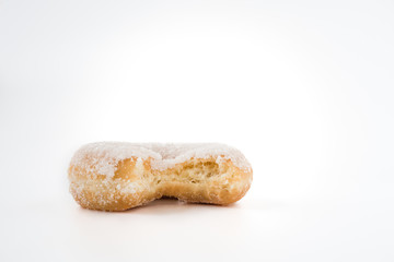 donut angebissen von vorne fotografiert und vor weißem hintergrund freigestellt mit viel freiraum fuer text