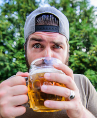 Beer and ale concept. Quench thirst. Hipster brutal bearded man hold mug cold fresh beer. Craft...