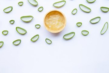 Aloe vera slices with aloe vera gel in wooden bowl on white