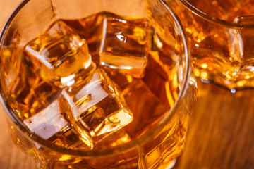 Macro Shot of Whiskey in Glass of Ice. Wooden bodies with alcohol