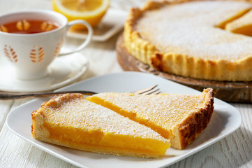 Homemade delicious lemon tart on white wooden background.