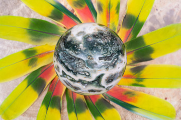Orbicular Ocean Jasper sphere with crystallized vugs from Madagascar in the middle of a circle made...