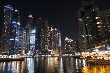 Illuminated skyscrapers from Dubai Marina reflected in water during the night