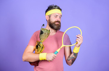 Athlete hold tennis racket and golden goblet. Win tennis game. Man bearded hipster wear sport outfit. Success and achievement. Tennis match winner. Achieved top. Tennis player win championship