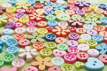 Fototapeta na wymiar .background of buttons of different shapes, colors and sizes on a plush fabric of light green color...