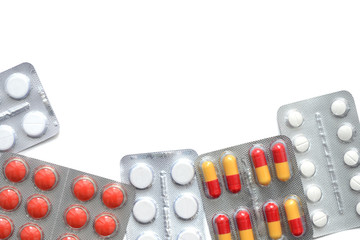 Packages with pills and tablets on white background close up