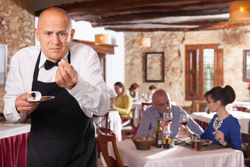 Fototapeta na wymiar Waiter expressing displeasure with small tips