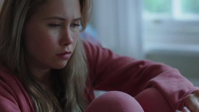 sad teenage girl alone at home feeling depressed moody teen thinking of emotional break up sitting in bedroom