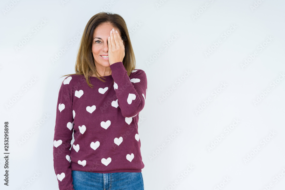 Sticker beautiful middle age woman wearing heart sweater over isolated background covering one eye with hand