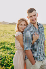 Young couple in love in summer in field.Couple hugging outdoor.