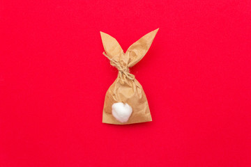 Obraz premium Easter bunny paper gift egg wrapping DIY idea on colorful background. Minimal easter concept, flat lay, copy space.