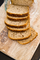 Wheat spelt bread slices on wooden cutting board