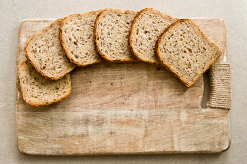 Slices of bread and wooden cutting board background.