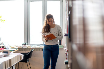 Female student reading book in library