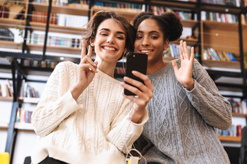 Two cheerful young girls students studying