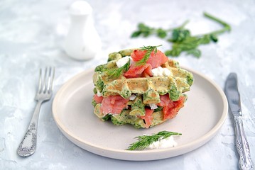 Light dinner, lunch or lunch, savory spinach snack waffles with salted salmon and cream cheese on a ceramic plate