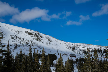 View on top of the mountains in the Zakopane area in Poland covered with fresh snow on the day with blue sky