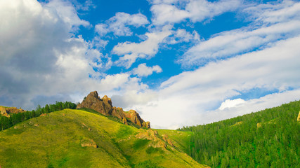 Fototapeta na wymiar Summer landscape high hill with large stones and blue sky with air clouds. Russia Siberia.