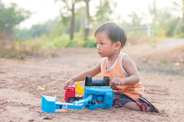 baby playing toy on soil outdoor