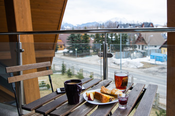 Morning breakfast on the balcony of the apartment in winter with a view of the mountains