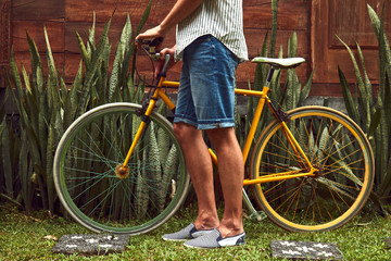 Naklejka premium Attractive man standing with old bicycle.