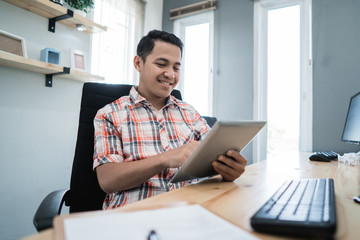 Fototapeta premium business owner relaxing using tablet at his office. small business owner