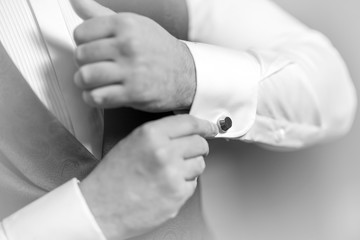 Hand's groom wears a metallic silver cufflinks stud. stylish wedding accessories.