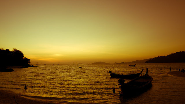 silhouette of a boat at sunset, summer beach landscape © grayjuice