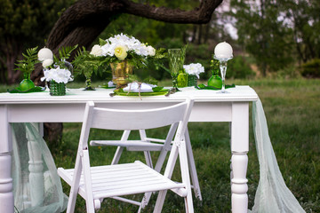 Wooden picnic table in scenic park with trees, flowers.