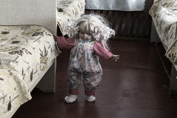 A creepy doll walks beside the bed. Obsessed doll stands next to the bed of the orphanage