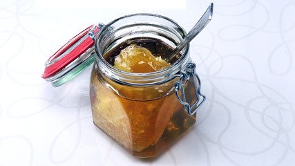 Raw organic honey - Honeycomb  in a jar. Natural, healthy and delicious sweet liquid from the bees.
