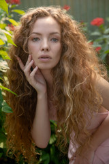 Pretty  girl with gorgeous curly hair in the garden. Dreaming.Spring