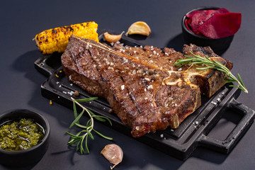 T-bone beef stake served on a cutting board, view from above