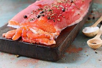 Gravlax, scandinavian beet cured spiced salmon on the board, top view, salted red fish