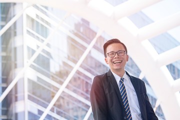 Fototapeta premium Successful businessman is smiling and laughing with happiness on modern building background